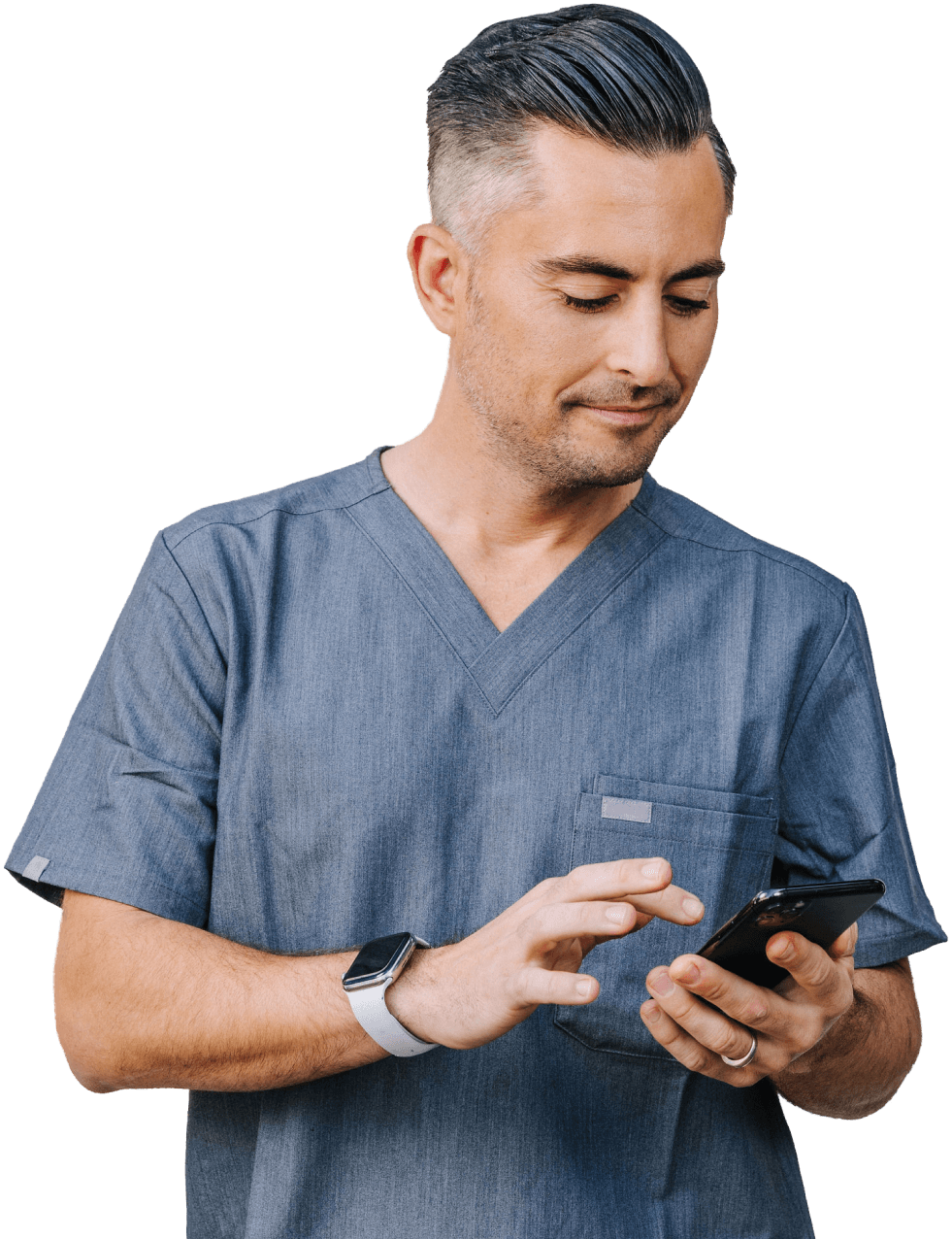 A healthcare professional in blue scrubs uses a smartphone