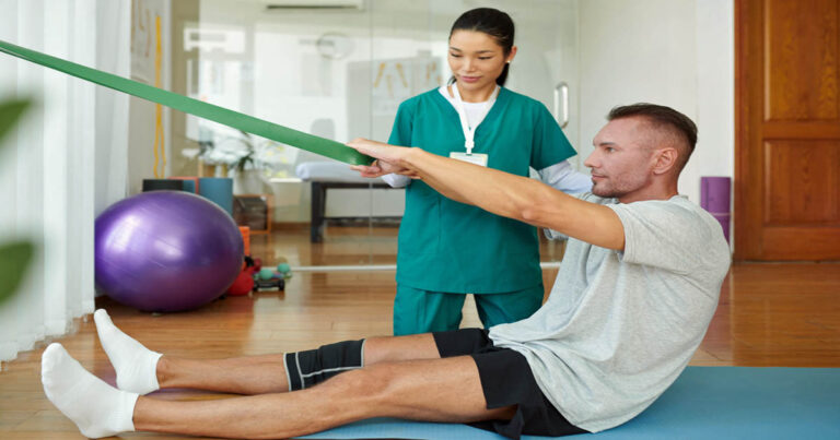 Physical therapist working patient to strengthen injured knee