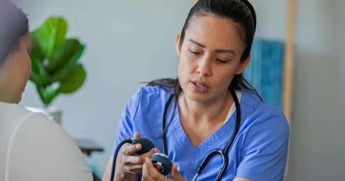 Licensed practical nurse taking patient's blood pressure